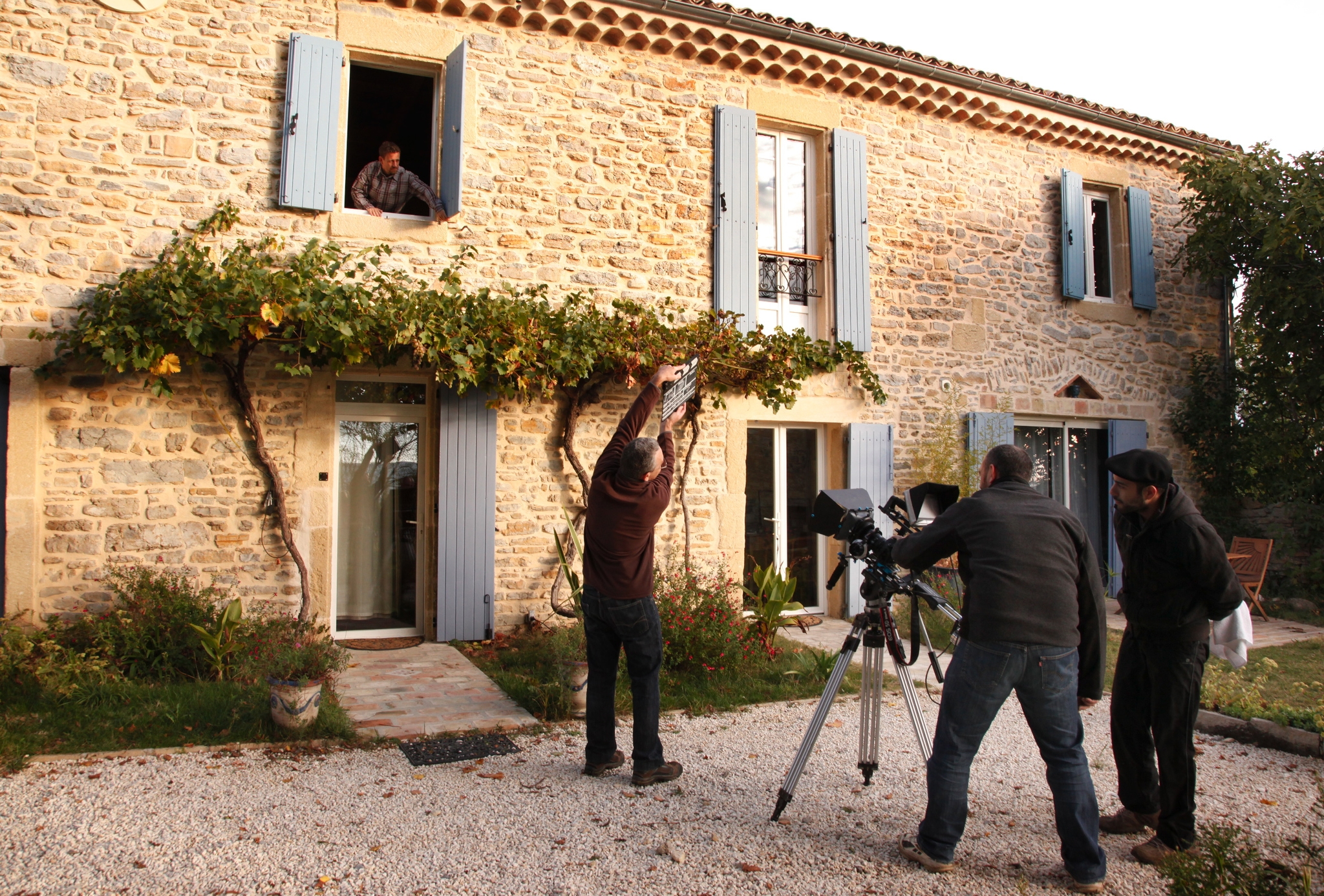 L’équipe filme la façade de la demeure et sa treille de vigne.