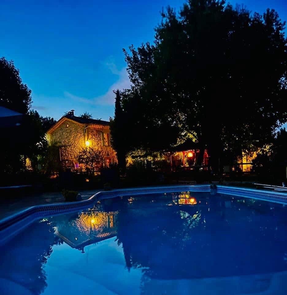 La piscine du domaine illuminée à la nuit tombée