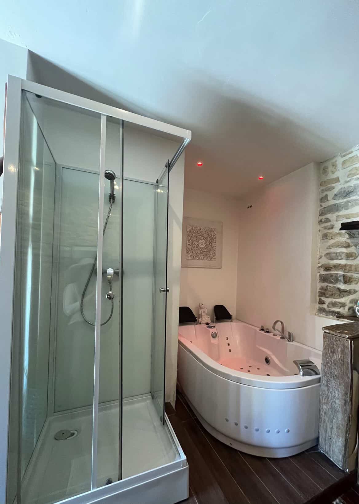 Salle de bain de La Suite : douche et baignoire balnéo dans l’ancienne écurie