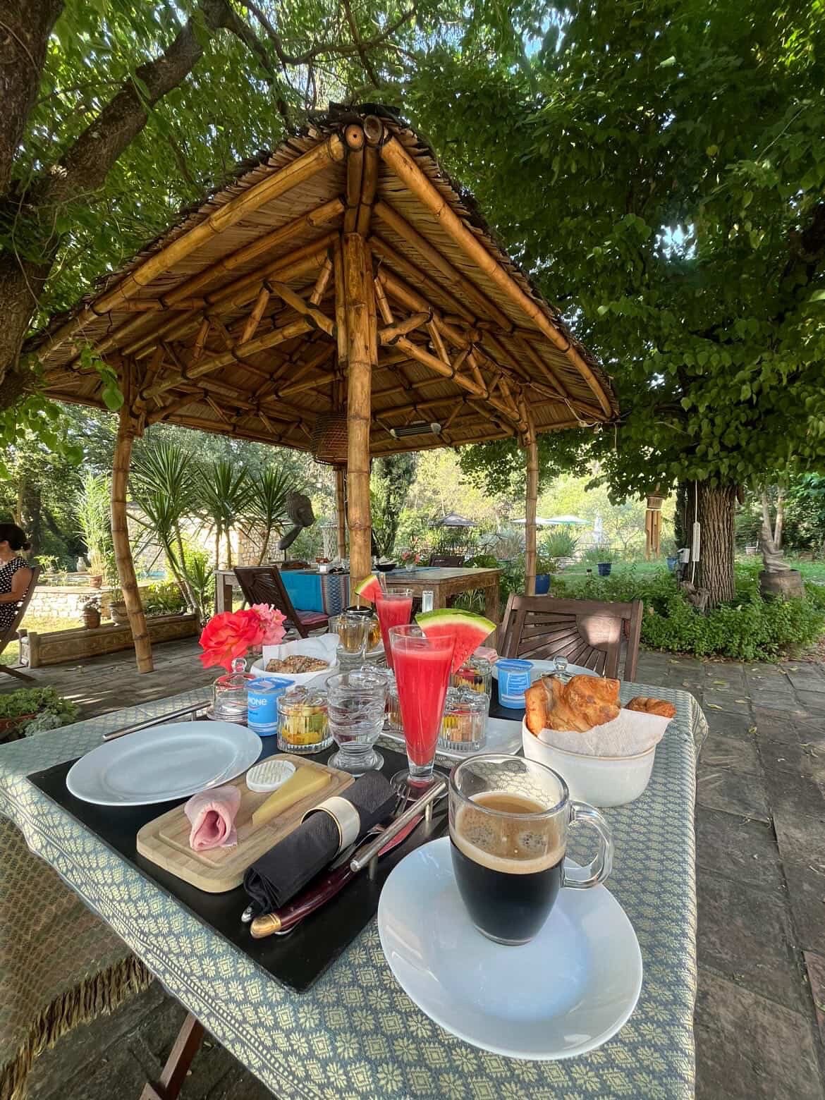 Petit-déjeuner et café servis sous le gazebo en bambou du jardin